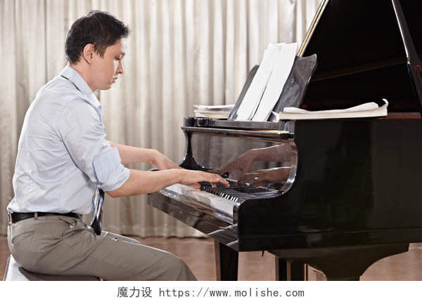 帅气的男人在舞台上弹钢琴